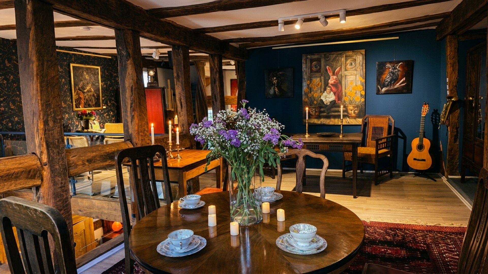 Der Living Room in Herborn: gedeckter Teetisch mit Blumenstrauß vor Kunst an nachtblauer Wand